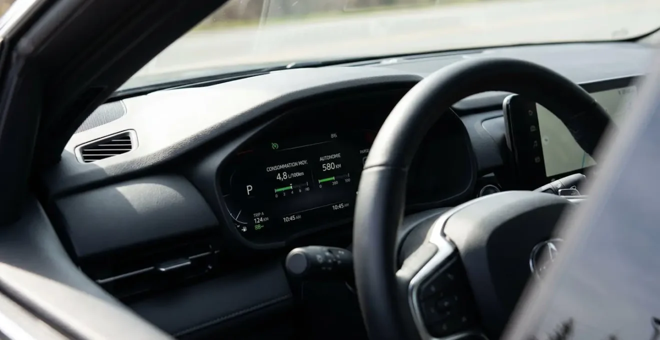 Tableau de bord de voiture moderne affichant une consommation instantanée de 4,8 litres aux cent kilomètres